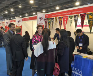 Bette Bergeron, SUNY Potsdam engaging with Chinese students at AASCU booth.